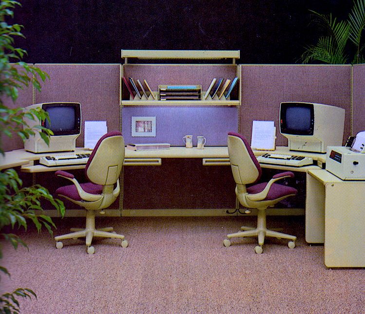 Early-80s office cubicle with two CRT terminal workstations